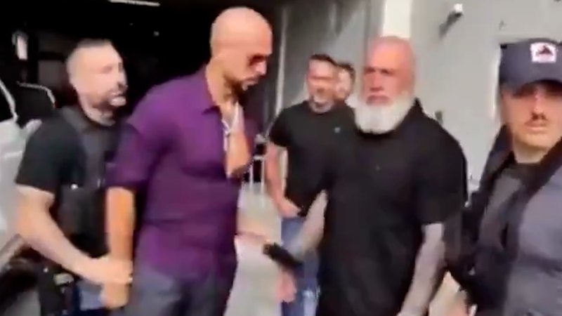 Andrew Tate hands off phone during arrest